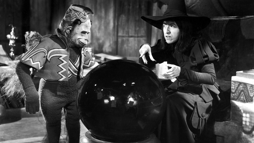 American actor Margaret Hamilton and a winged monkey look into a crystal ball in a still from the film, 'The Wizard of Oz,' directed by Victor Fleming, 1939.